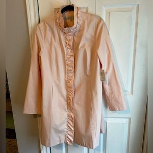 Ladies pastel pink overcoat with ruffle detail.